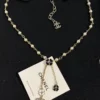 Chanel black and white four-leaf clover enamel necklace